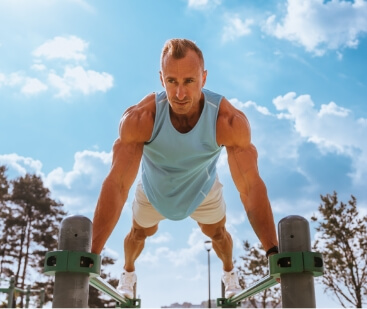 focused-athletic-man-holds-a-plank-on-outdoor-gym-2025-03-18-23-15-24-utc